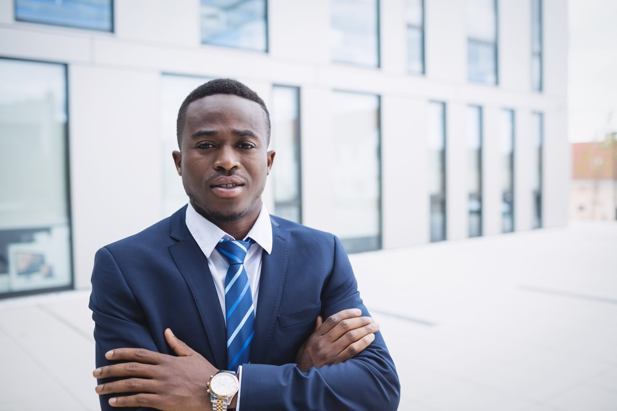 Portrait of a businessman with arms crossed standing outside office building